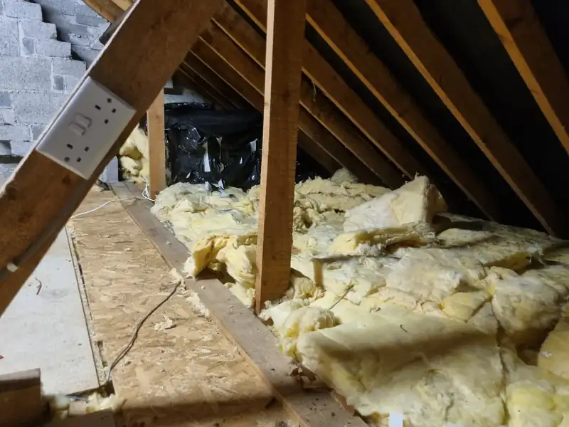 Cleared attic showing insulation and boarded area after clearance