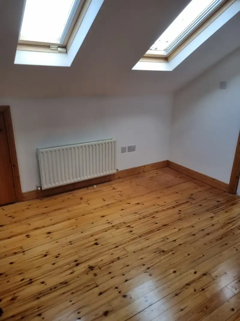 Empty attic bedroom with wooden floor after clearance