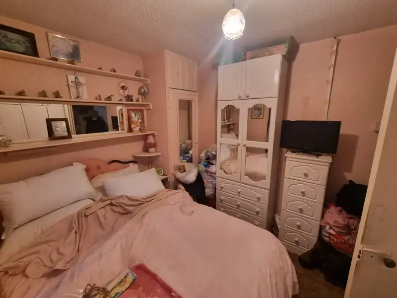 Bedroom with wardrobes and bedding before a house clearance