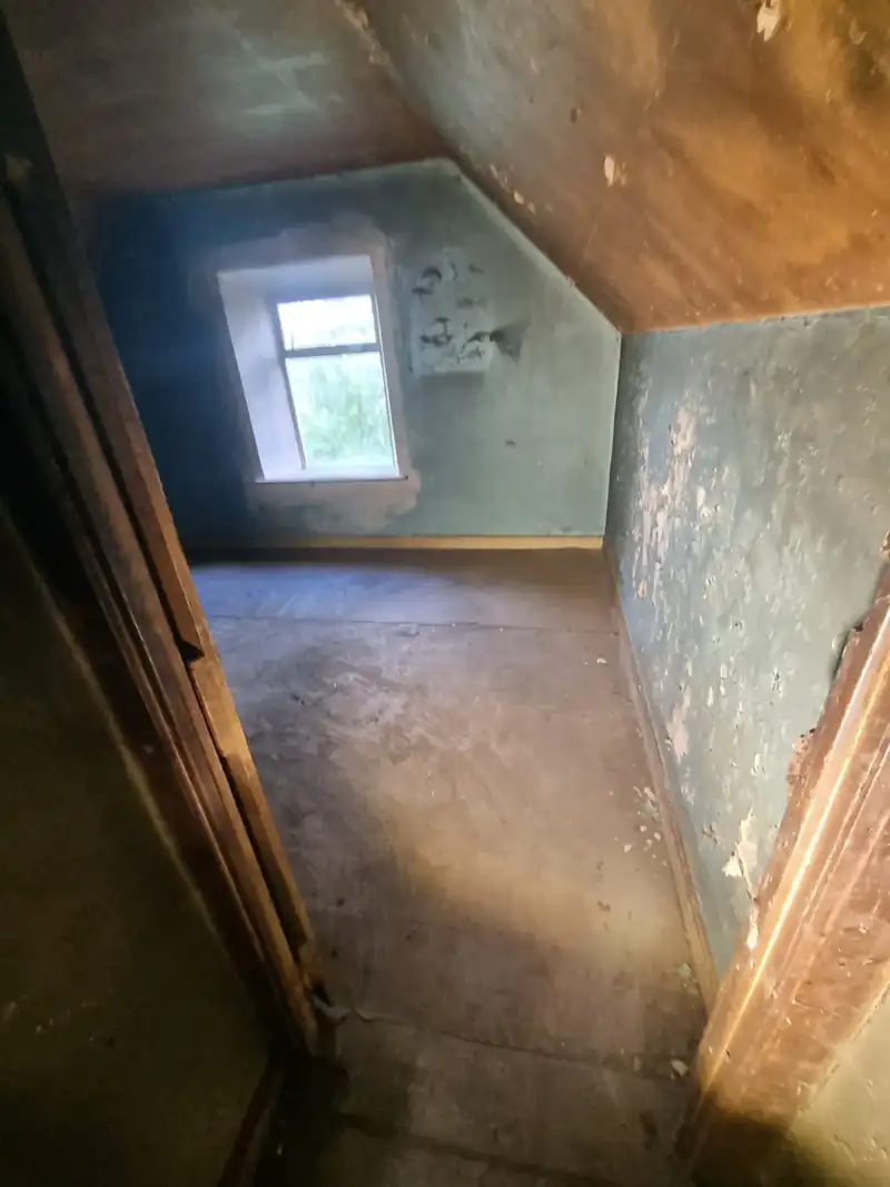 Cottage room cleared to bare floor after a hoarder clearance