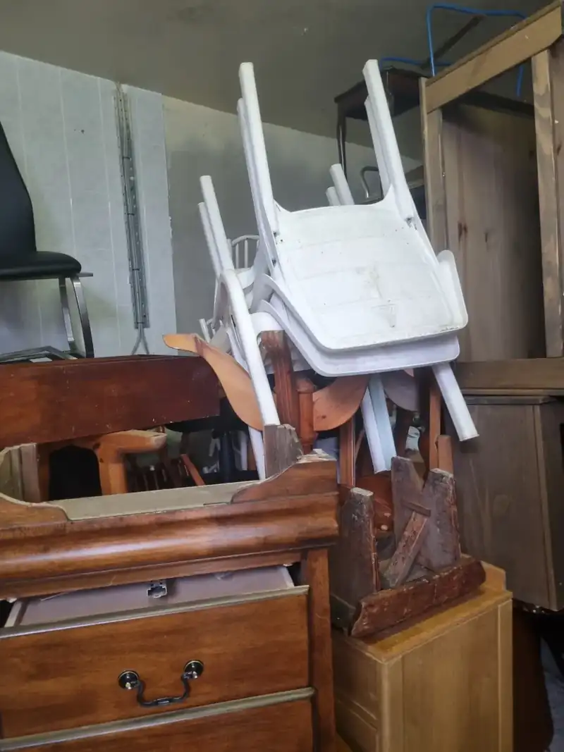 Chairs and chests of drawers stacked for furniture removal