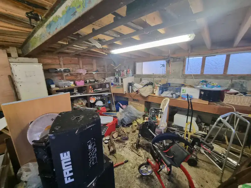 Garage full of bikes, boxes and stored equipment before clearance