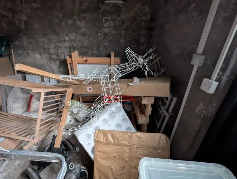 Garage packed with tools, bed frames and boxes before a garage clearance