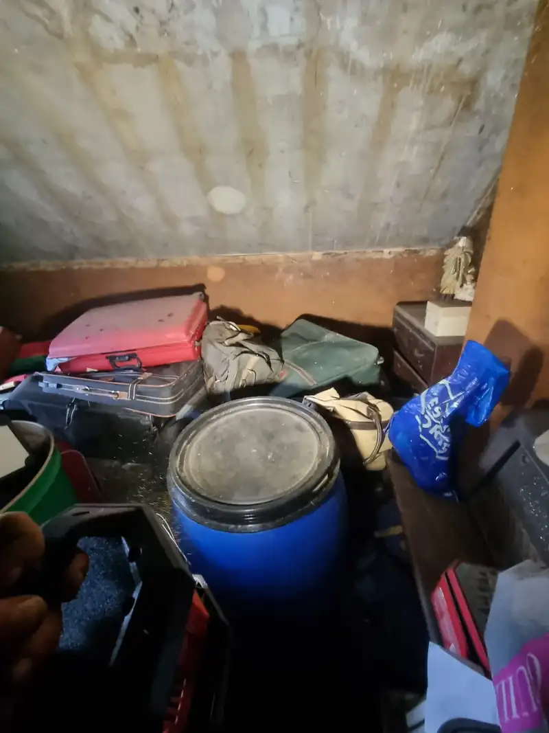 Hoarded room with barrels and belongings before clearance