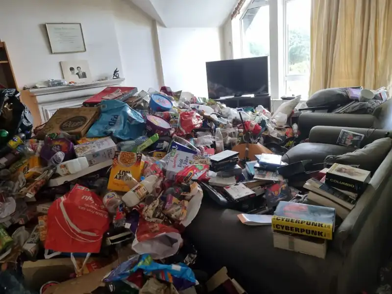 Living room piled with belongings before a hoarder clearance in Dublin