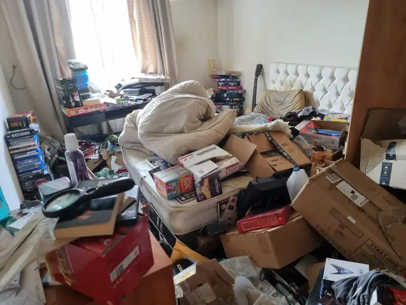 Hoarded room in Dublin stacked with boxes and belongings before clearance