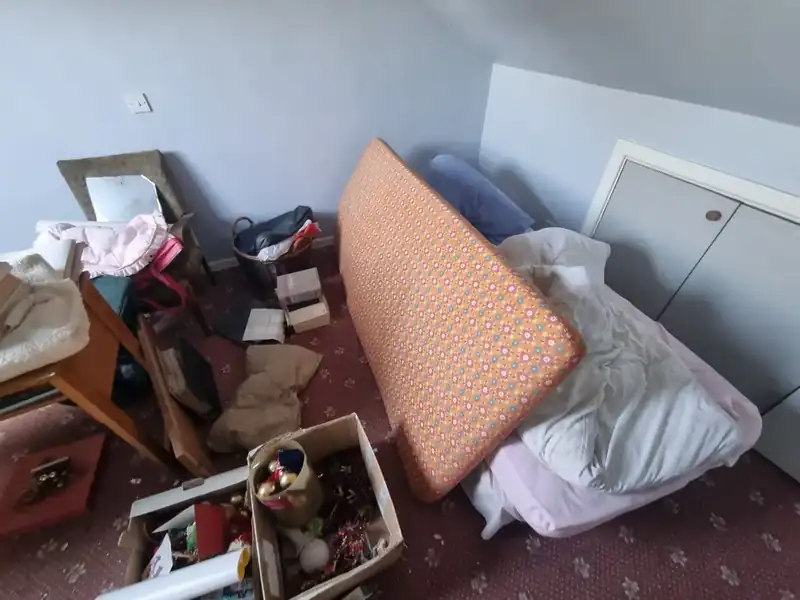Room with mattress, boxes and clutter before a clearance in Dundrum