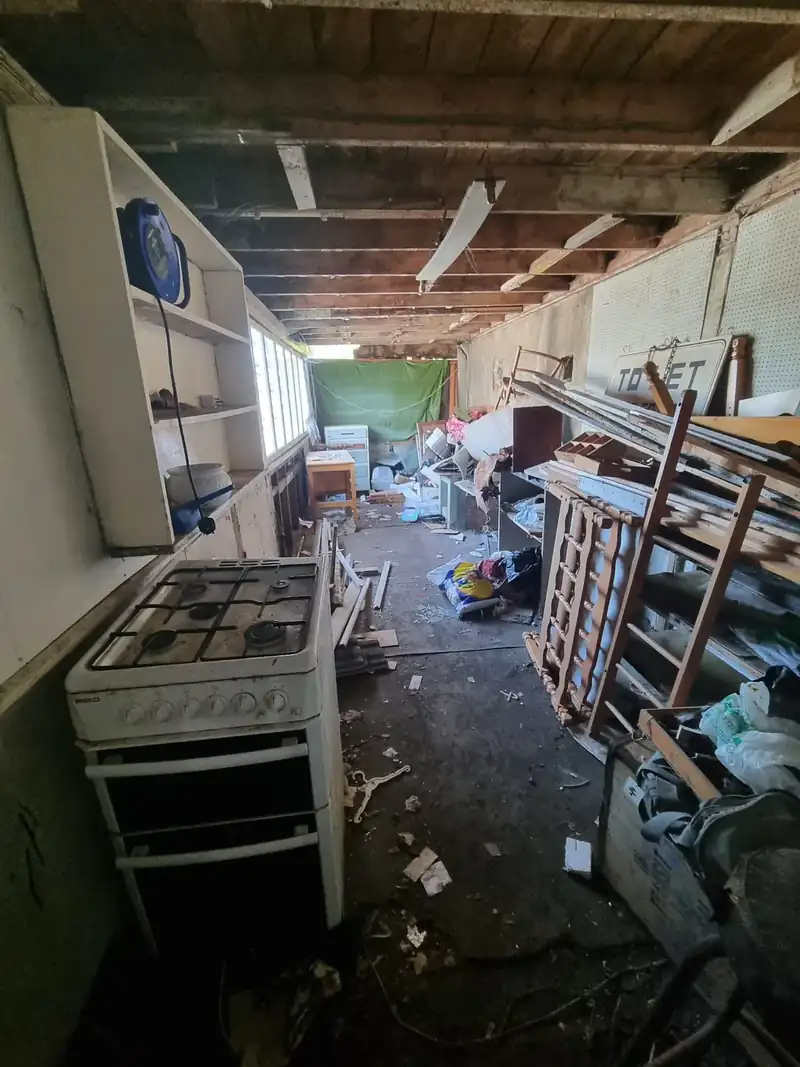 Shed interior full of junk and old equipment before a shed clearance