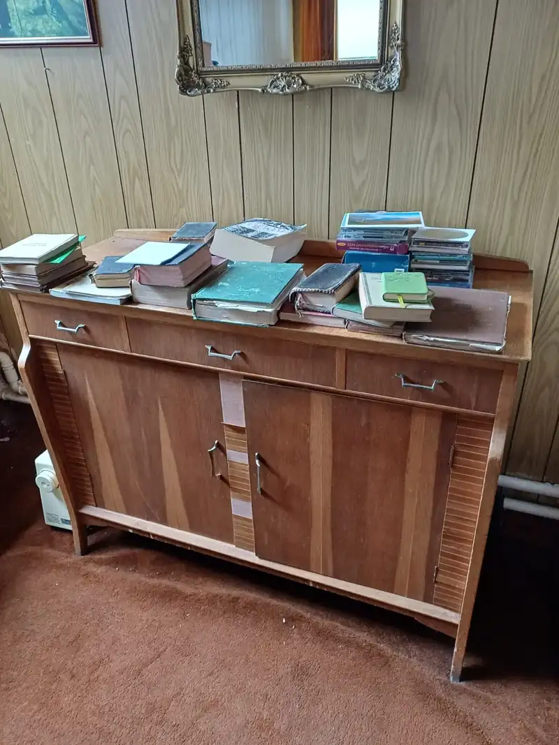 Sideboard and books being cleared from a family home