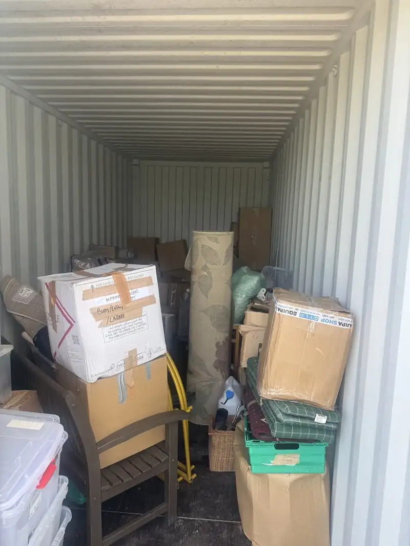 Storage unit full of boxes and furniture before clearance
