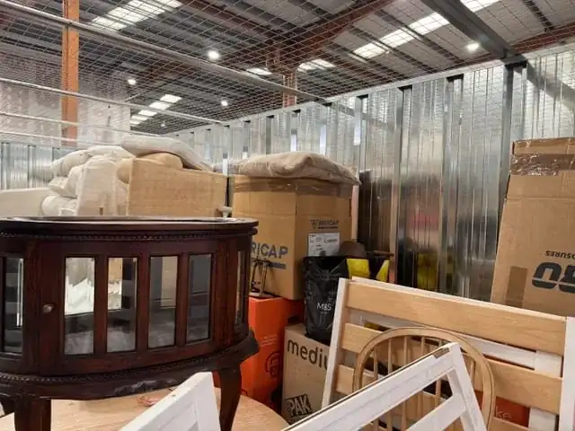 Furniture and boxes inside a warehouse unit before clearance